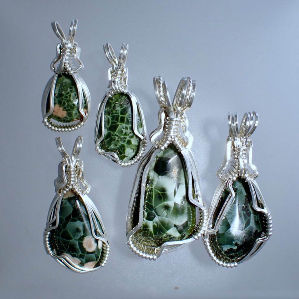 5 Greenstone pendants, wrapped in silver wire